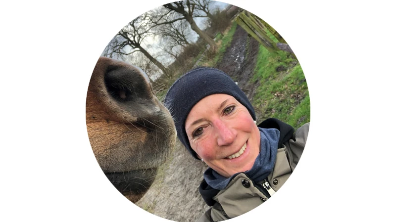 Anja Rose neben dem Kopf eines Pferdes